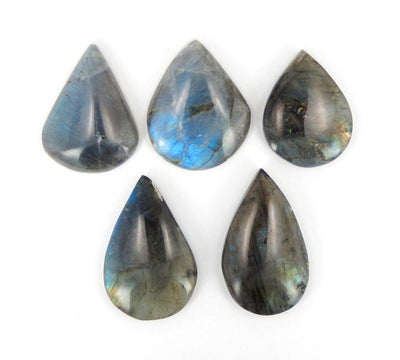 multiple Labradorite Teardrop Cabochons displayed on white background to show various widths lengths shades of gray and fluorescent luminescence between each stone
