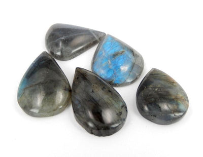 side view of multiple labradorite teardrop cabochons for thickness reference