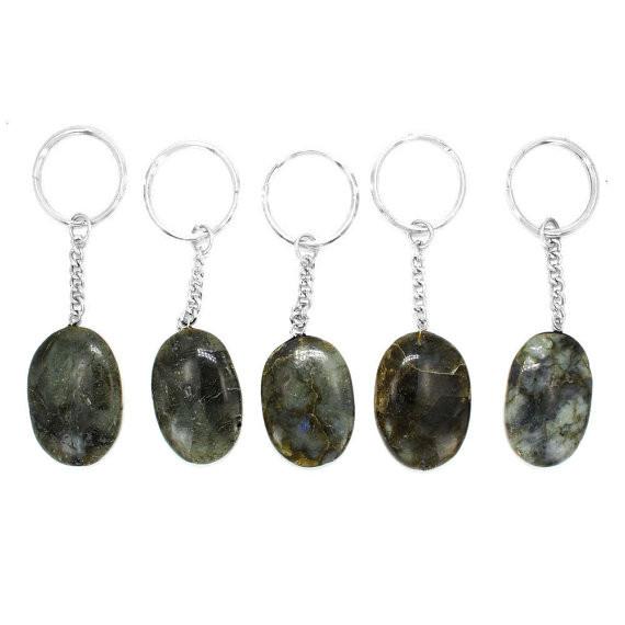 multiple labradorite worry stone keychains displayd to show the differences in the color shades and sizes 