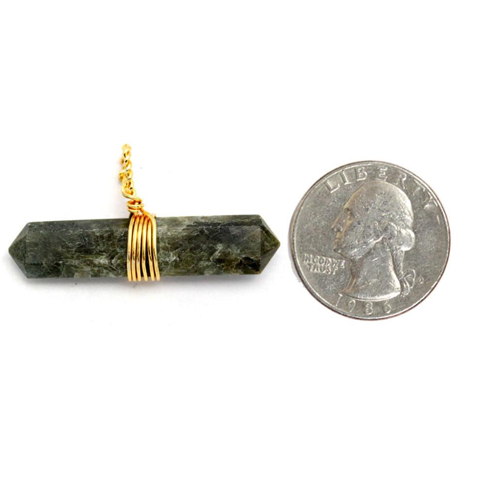 labradorite point pendant next to a quarter for size reference