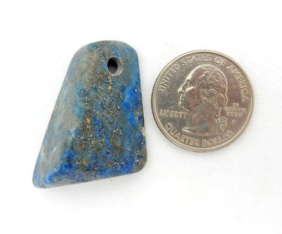 Tumbled lapis lazuli bead next to quarter for size reference