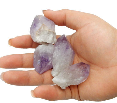 hand holding up 4 large amethyst points