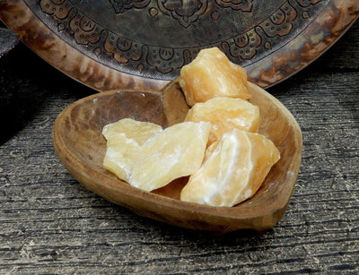 Orange Calcite Stone - a few pieces in a wood bowl