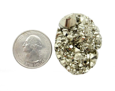 Large Pyrite Oval Cabochon next to a quarter for sizing