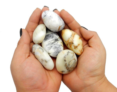 hands holding up large tumbled agate stones
