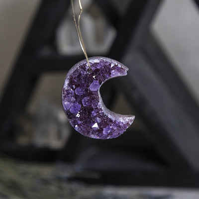One amethyst moon handing from a wire to show the drill hole