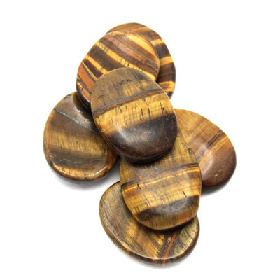 pile of tiger eye worry stones on white background