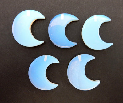 Five Opalite Half Crescent Moons - Drilled, displayed on a black surface.