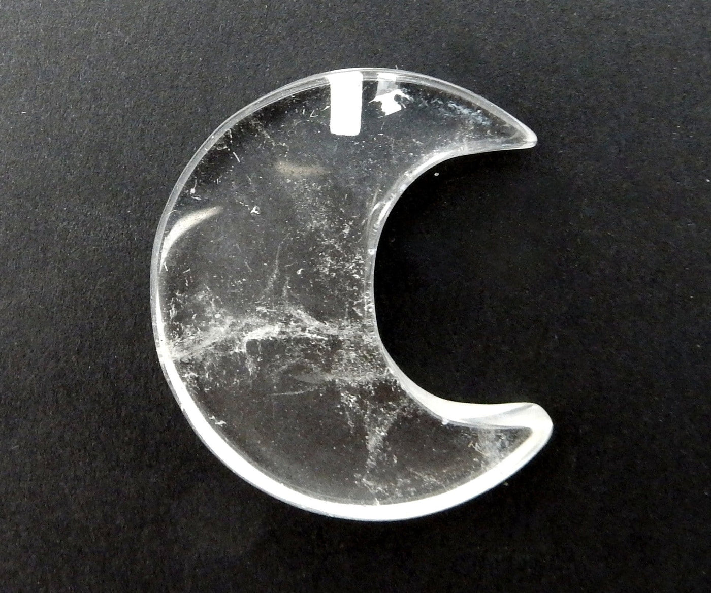 Crystal Quartz Half Crescent Moon - Drilled, displayed on a black surface.