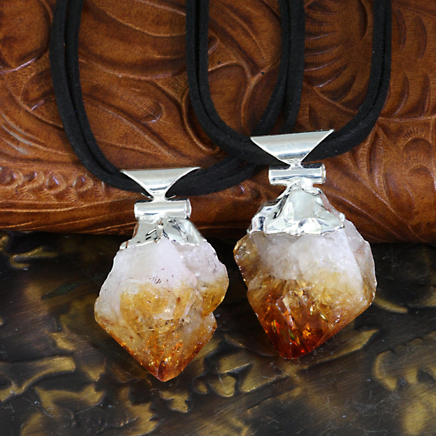 Two citrine point necklaces with silver plated tops and a black double cord.