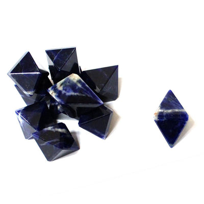 many sodalite diamond shaped points in a pile with one off to the side
