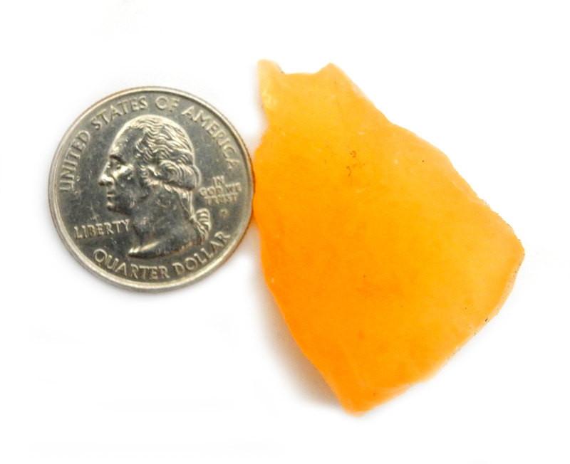 Orange Calcite next to a quarter