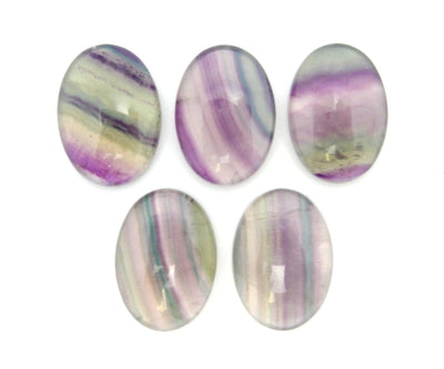 Oval Shaped Fluorite Cabochon displayed on white background close up to show color and characteristic variations