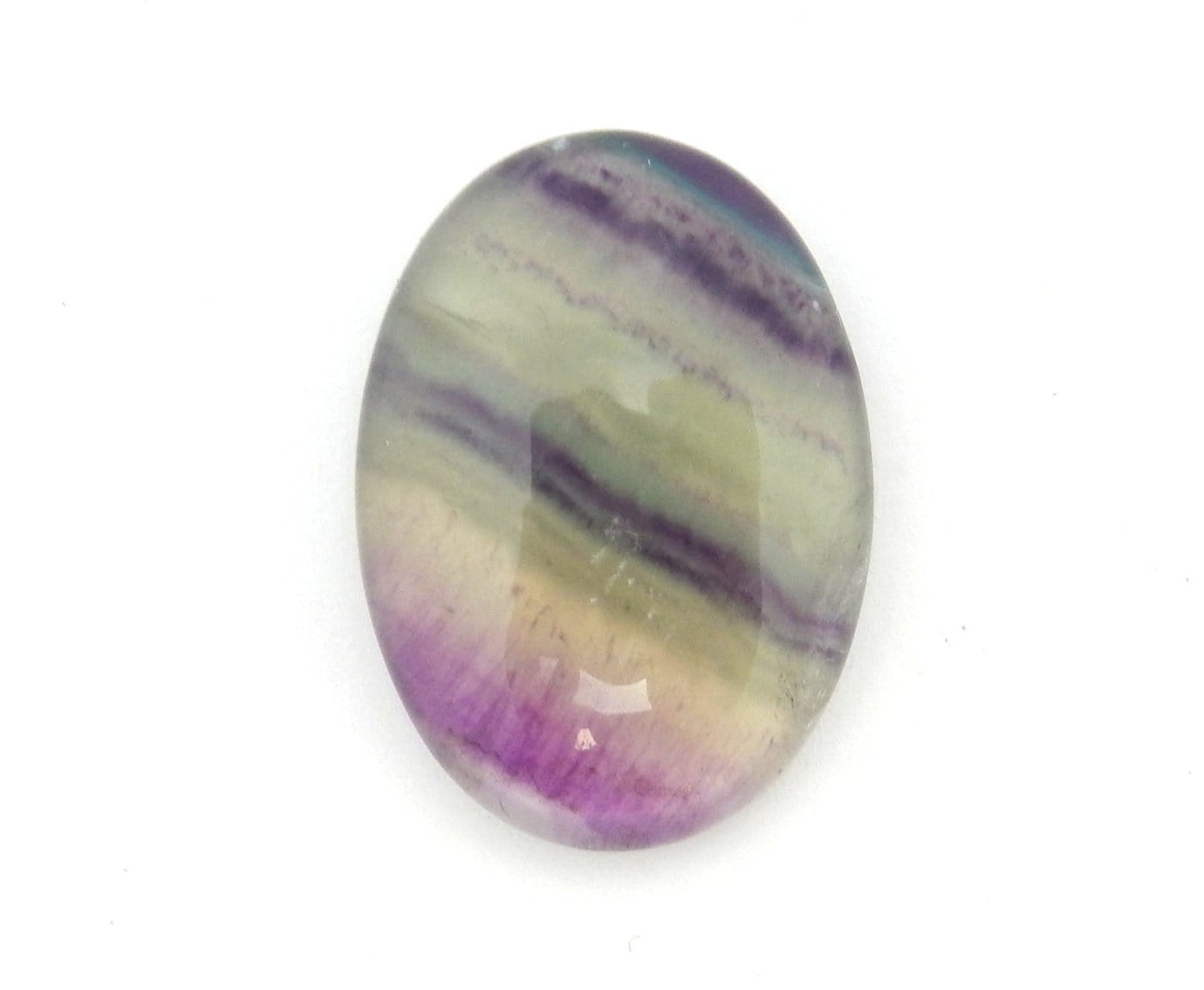 Fluorite Cabochon displayed up close to show details and shades of green purple and clear