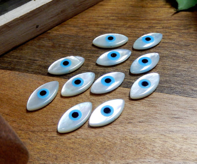 angled shot of 11 mother of pearl Greek eyes on wooden background