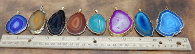 in this Picture the agate slice pendants are being displayed in front of a ruler, for size reference. 