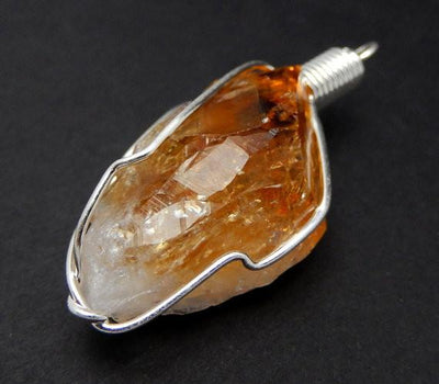 close up of the details on this citrine pendant with silver wire wrapping 
