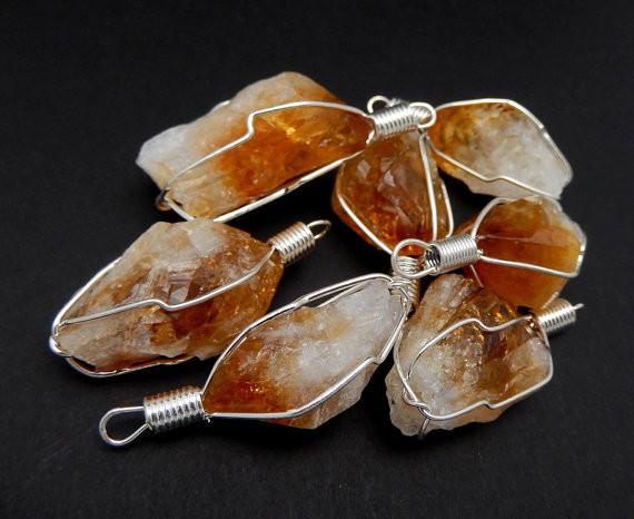 multiple citrine pendants displayed to show the differences in the crystal type