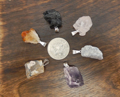 Rough Stone Pendants surrounding a quarter for size reference