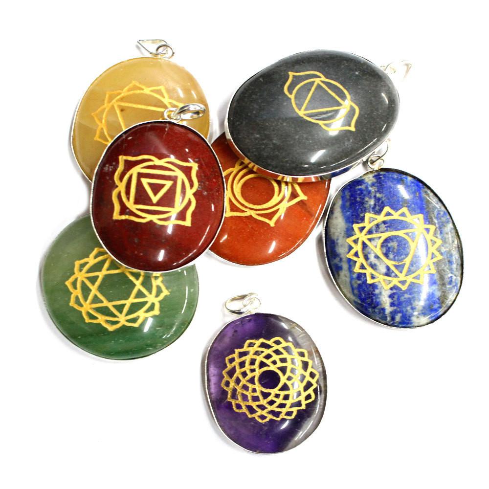 seven chakra stone pendants in a pile