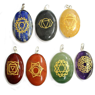 overhead view of seven chakra stone pendants laying flat for engraving details