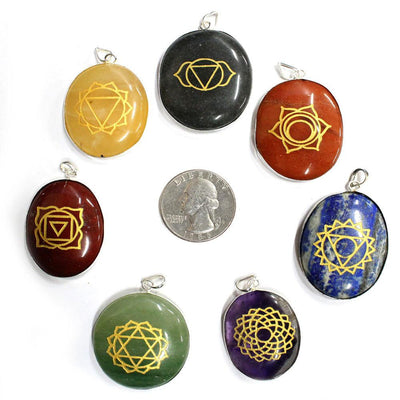 seven chakra stone pendants with quarter for size reference