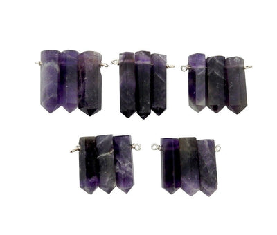 Multiple triple amethyst pencil point pendants displayed to show variation in size and characteristics