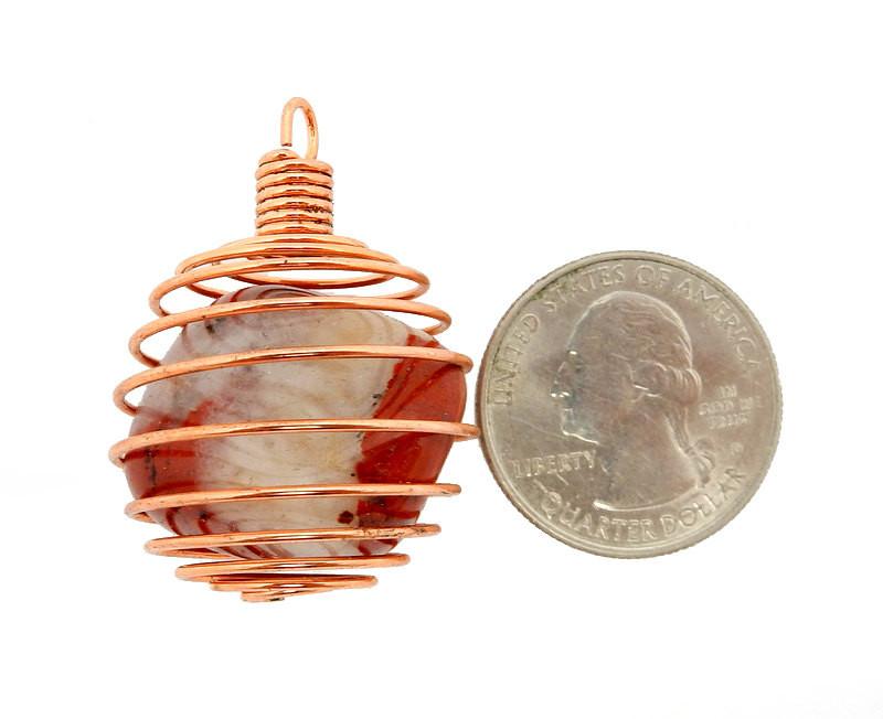 copper toned wire cage next to a quarter for size reference 