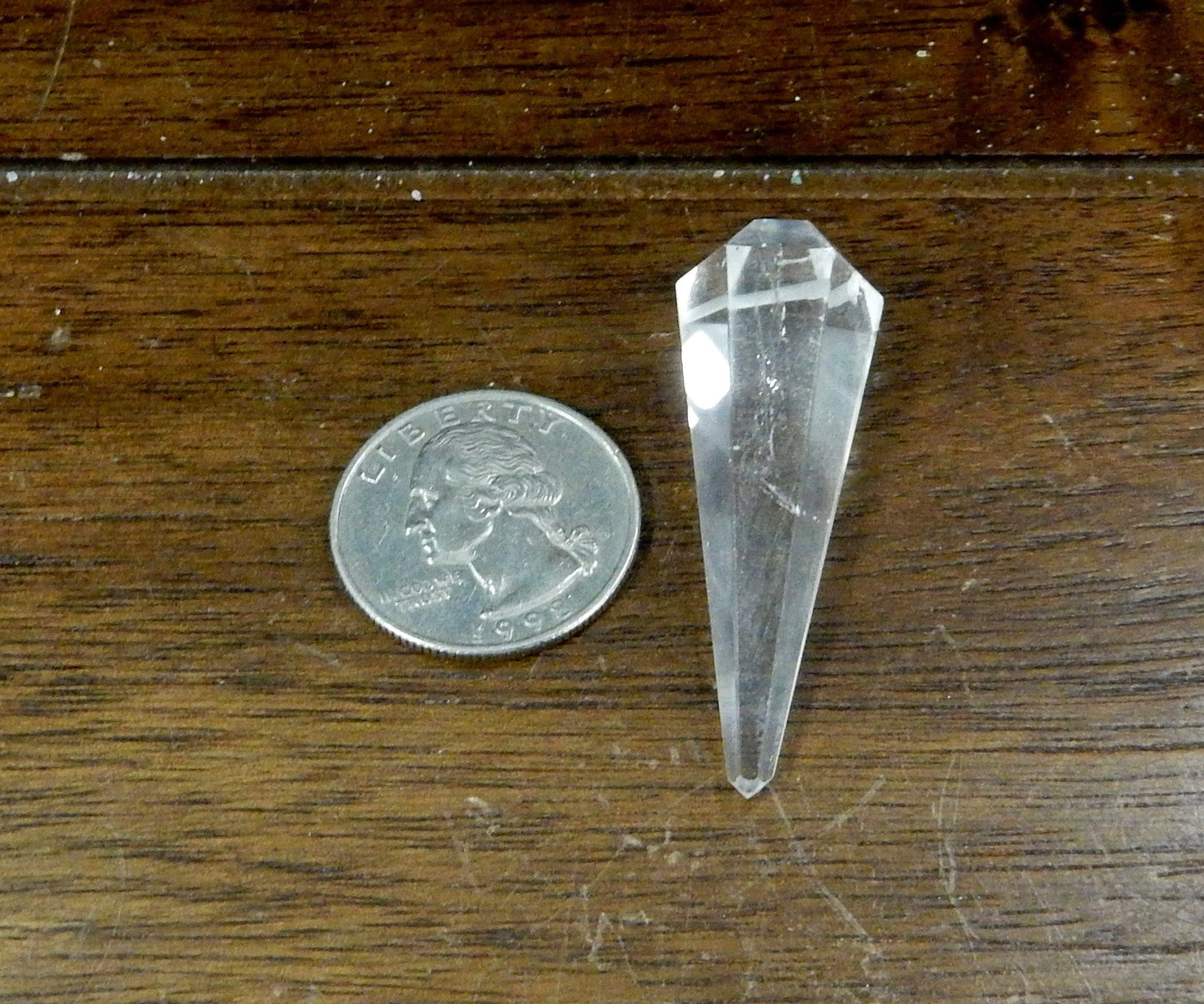 Crystal Quartz Pendulum Point Top Side Drilled Bead next to a quarter for size comparison