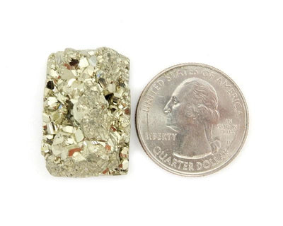 Single Petite Pyrite Rectangle Cabochon next to quarter for size comparison