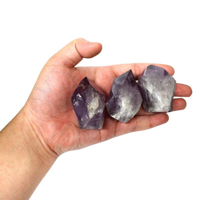 hand holding up 3 amethyst points