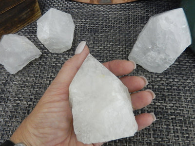 Crystal Quartz Semi Polished Points with a size 300-400g size in a hand for size reference