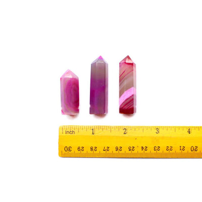 3 Pink Agate Drilled Pencil Points lined up above a ruler for size reference