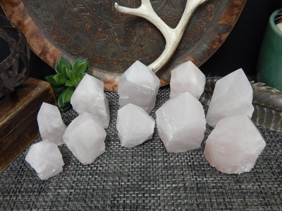 Top view of different sized Rose Quartz Semi Polished Points with decorations