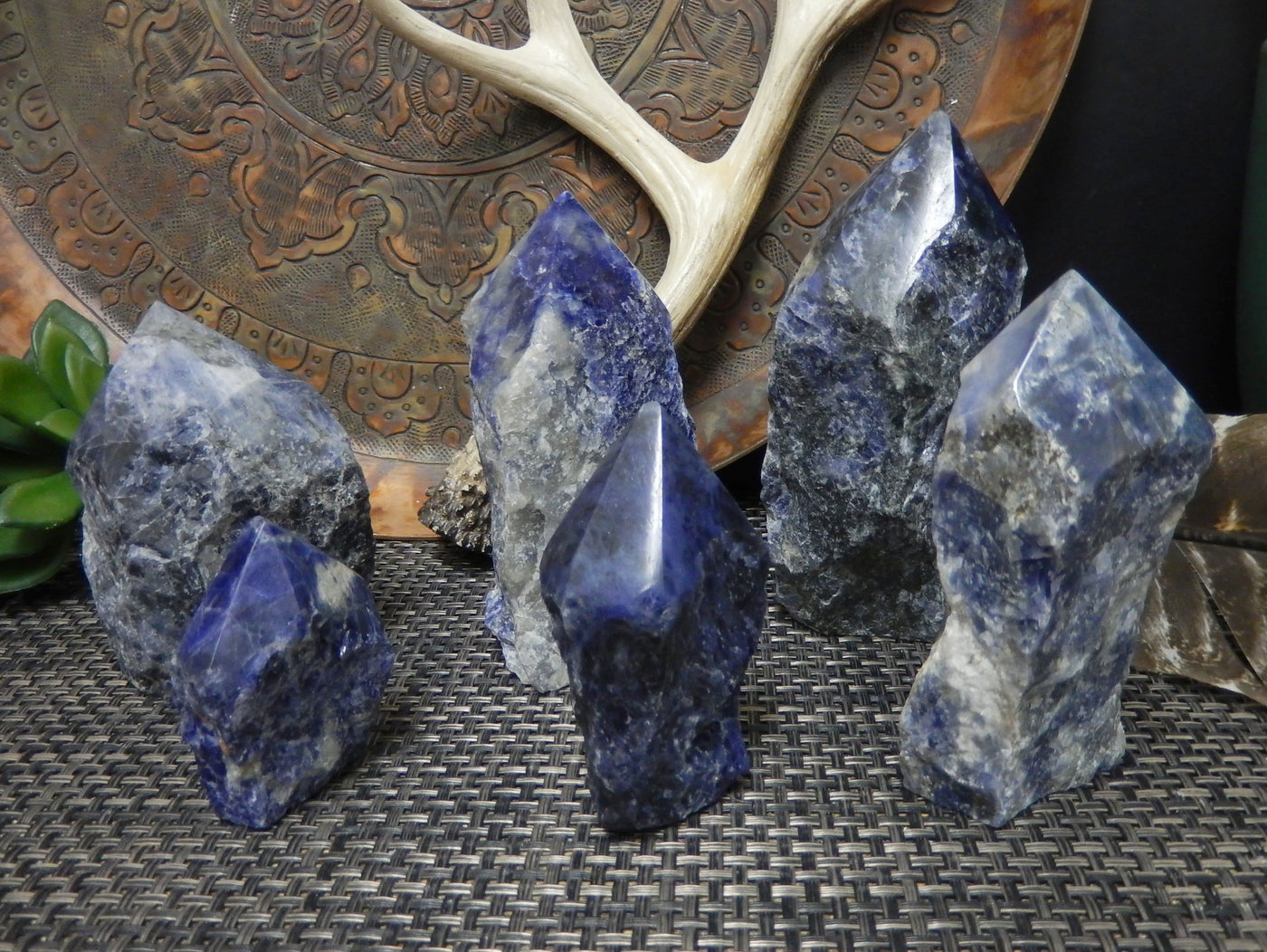 6 sodalite semi polished points in different sizes with decorations in the background