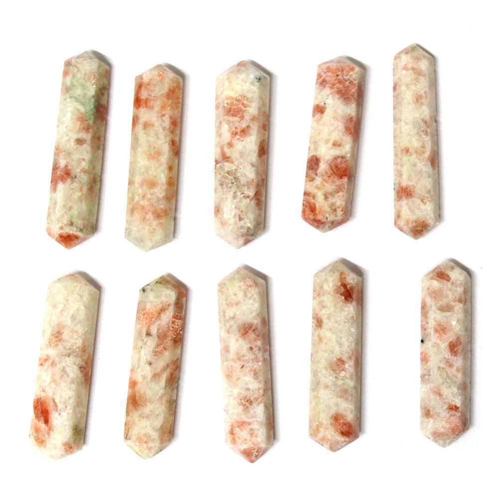 10 sunstone double terminated points lined up on white background