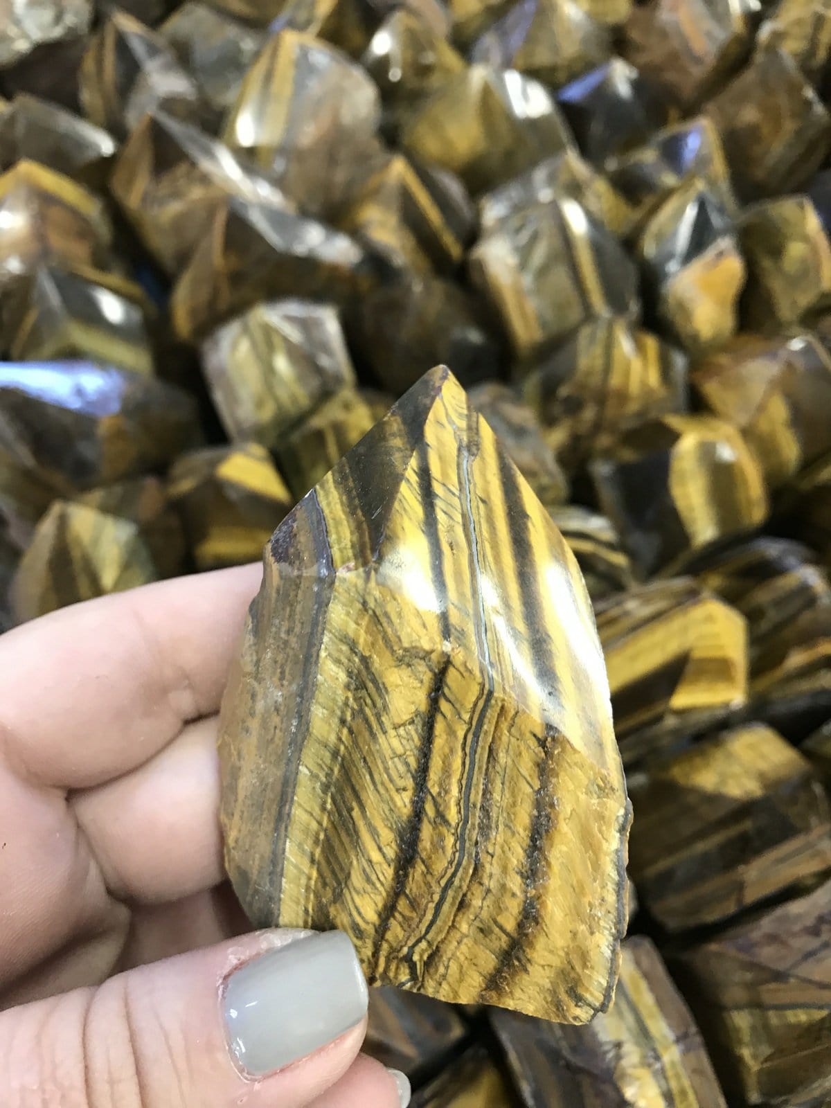 tiger eye polished point in a hand.