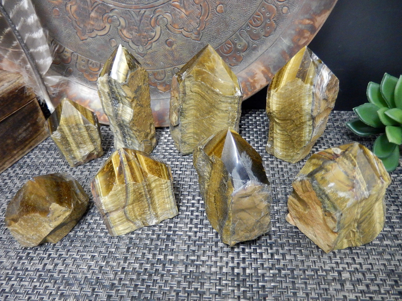 Assorted semi polished tiger eye points on a brown background.
