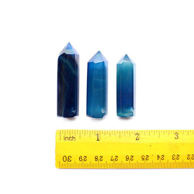 3 blue agate drilled points next to a ruler for size reference on white background