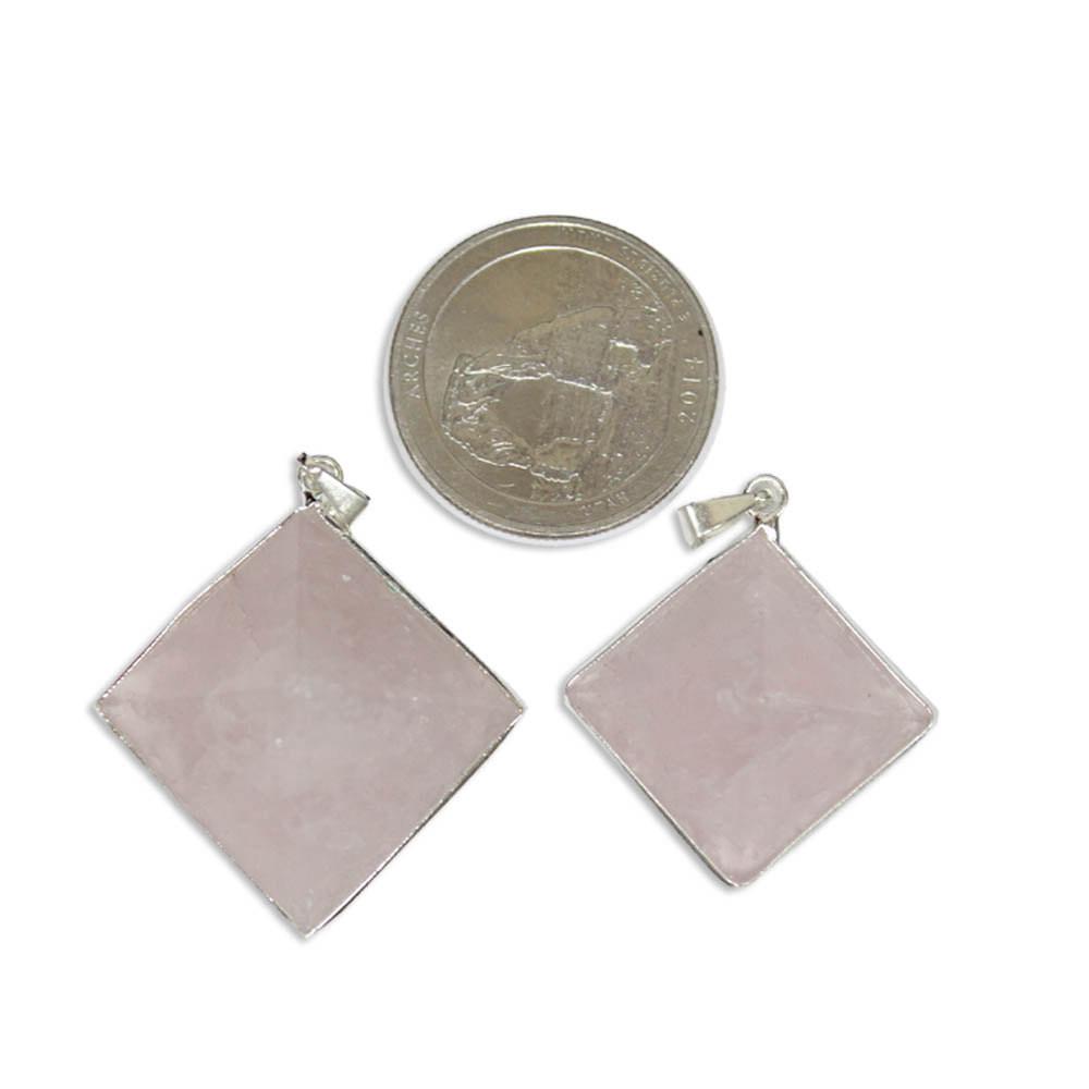 2 Rose quartz Pyramid Pendants next to a quarter for size comparison on white background