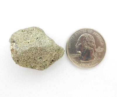 pyrite nugget next to  a quarter for size reference