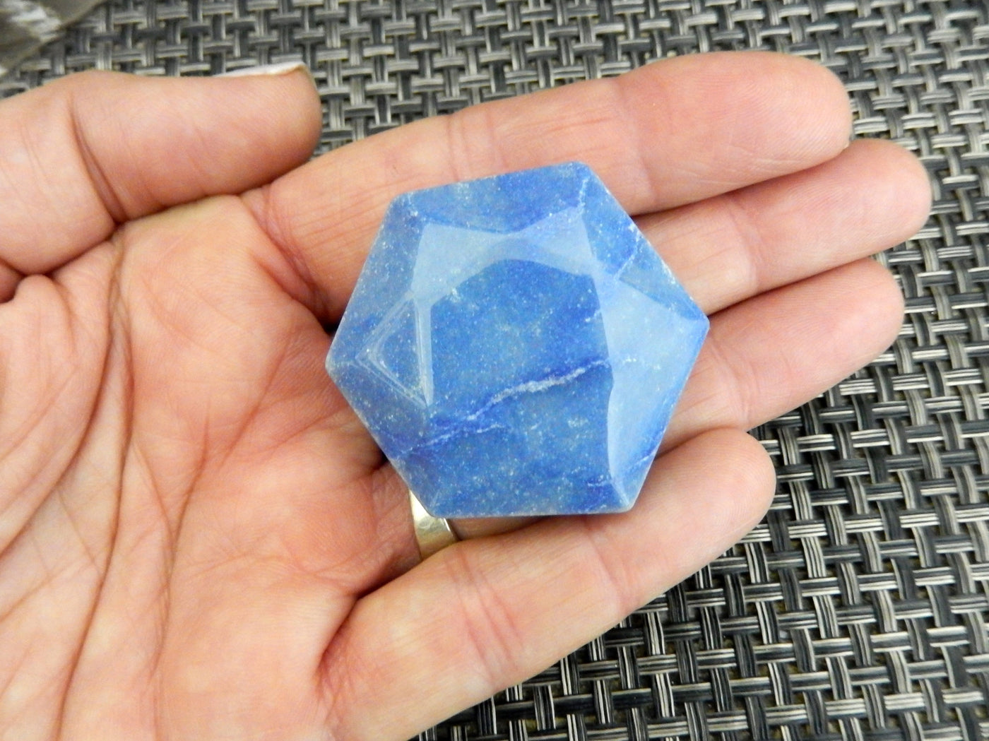 small blue quartz hexagon in hand for size reference 