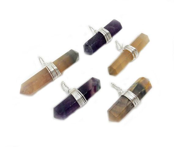 Angled shot of 5 Rainbow Fluorite Double Terminated Point Pendants with Silver Wirewrapped Bails on white background