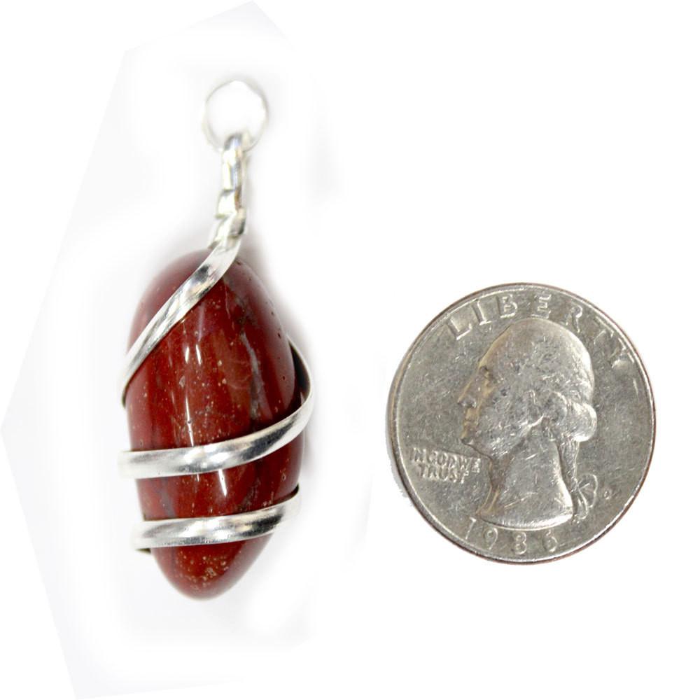 Red Jasper Pendant next to a quarter for size reference on white background