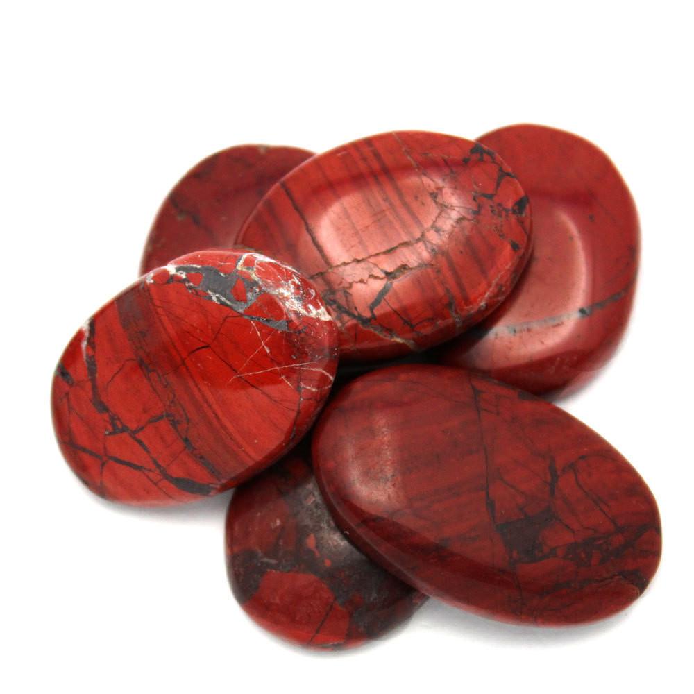 Pile of Red Jasper Worry Stone Slabs on white background