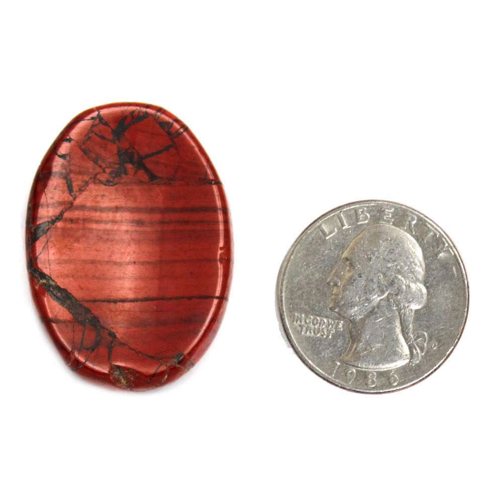 Red Jasper Worry Stone Slab next to a quarter for size reference on white background