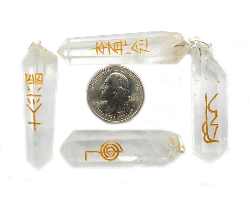 4 Reiki Crystal Quartz Point Pendants surrounding a quarter for size reference on white background