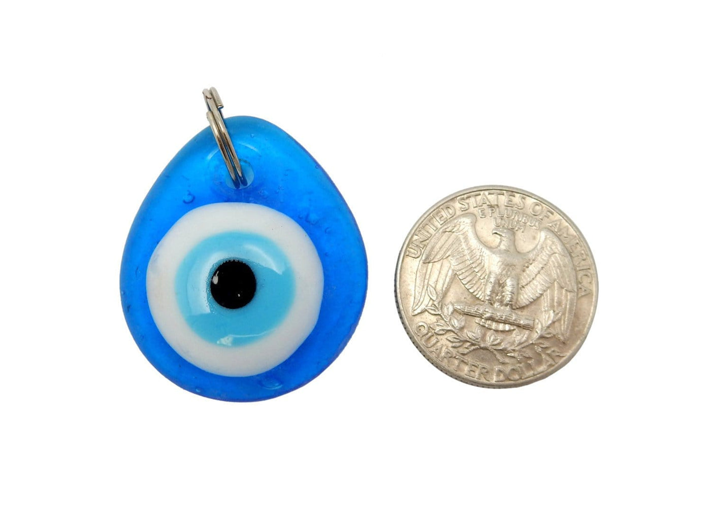 Resin Eye Pendant next to a quarter for size reference on white background