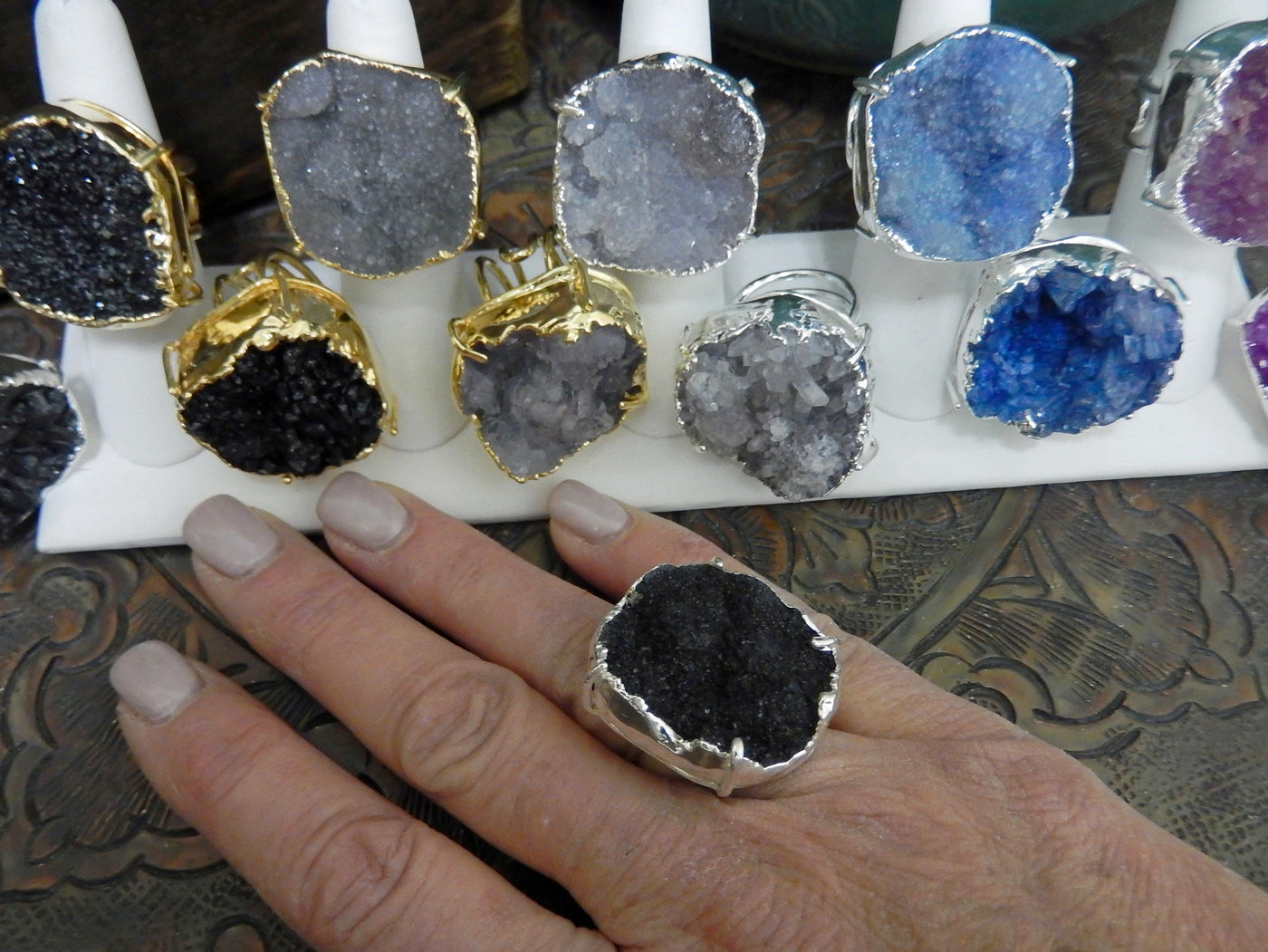 Druzy Rings displayed in electroplated 24k gold and silver and one ring on hand for size reference