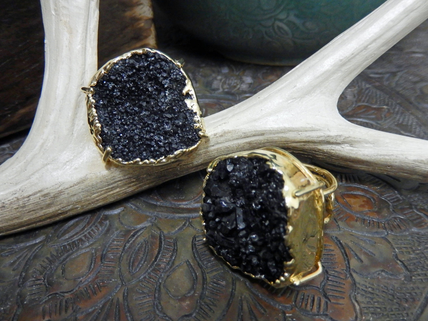 front and side view of dark druzy rings in gold